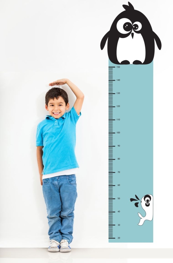 boy measuring himself on wall chart