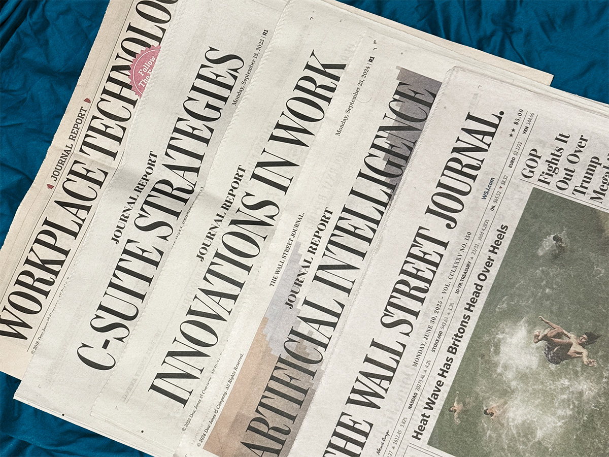 Stacks of WSJ section front pages, titled Workplace Technology, C-Suite Strategies, Innovation in Work, Artificial Intelligence and The Wall Street Journal